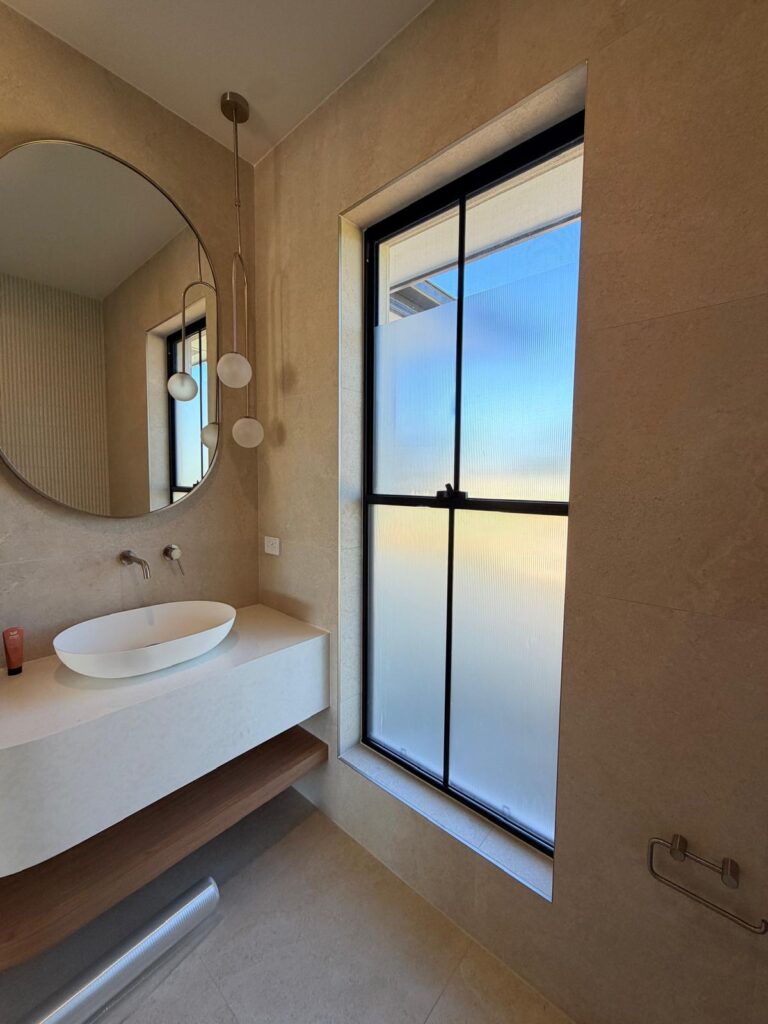 Residential bathroom window with frosted privacy film for light and privacy