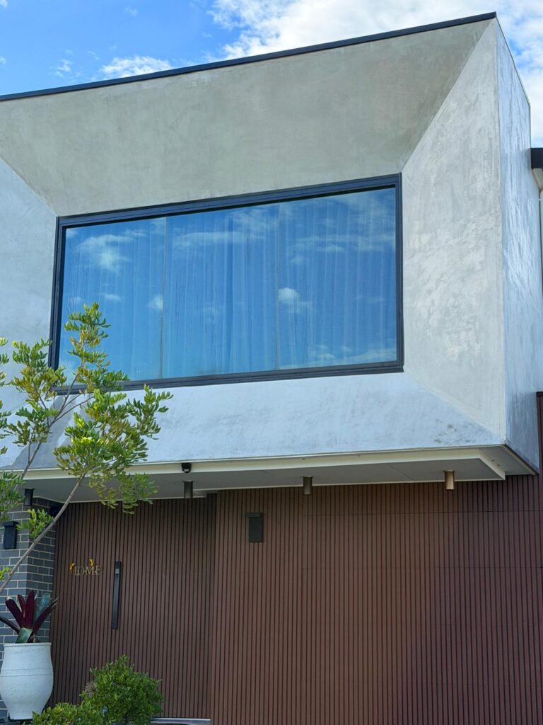 Large architectural glass window with professional window tinting installation in Sydney
