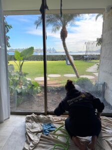 Platinum Tint Solutions technician applying window film to large glass windows in Sydney